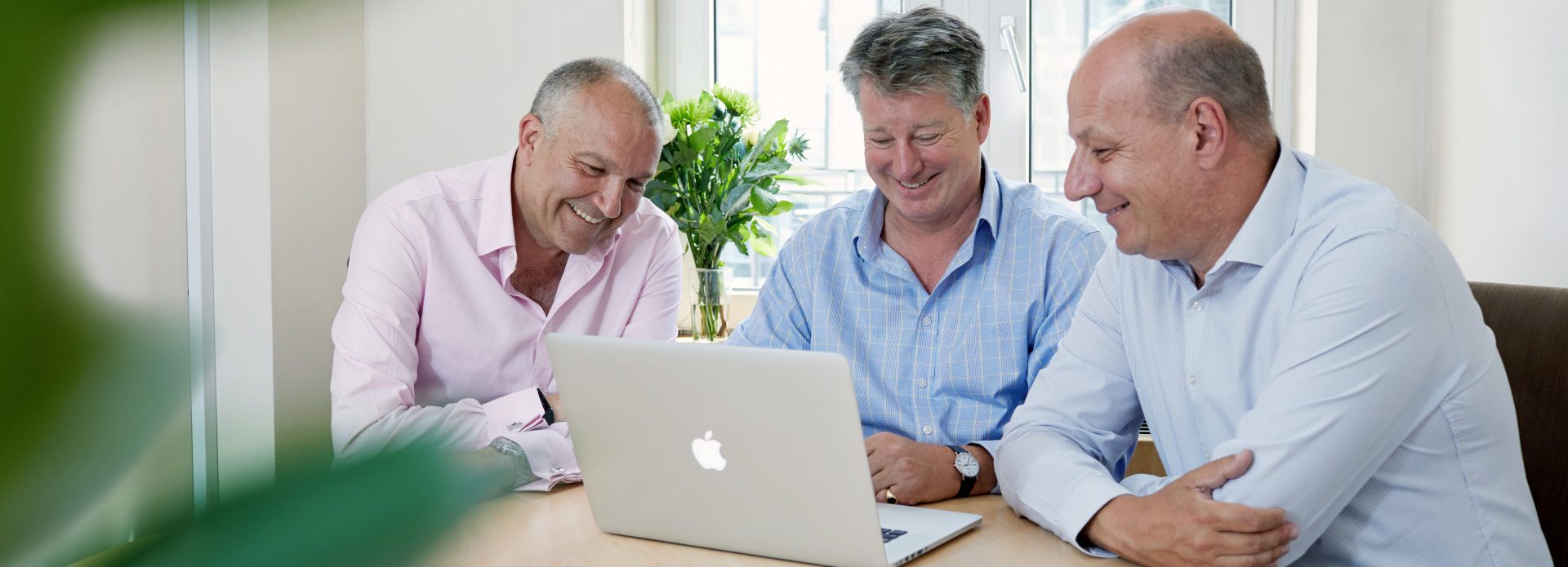 3 business men looking at laptop